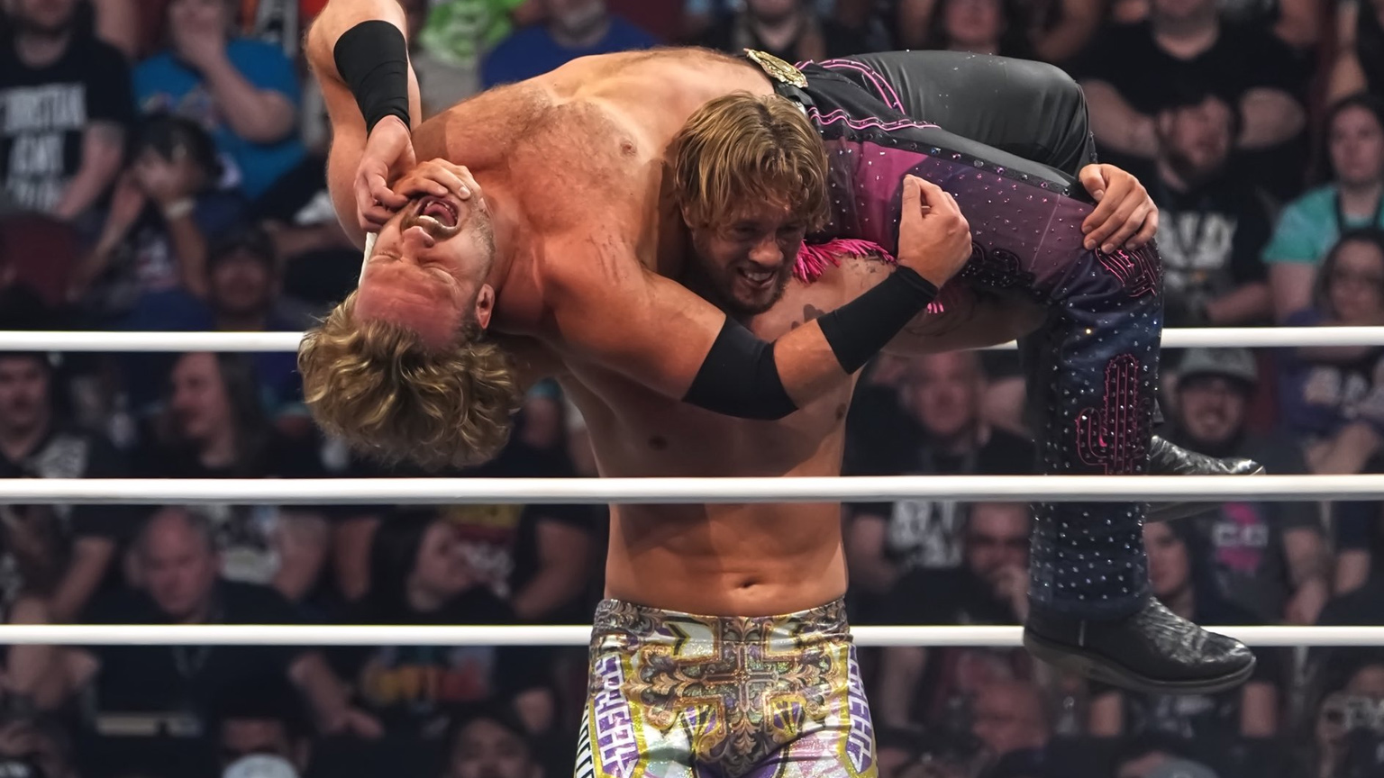 Will Ospreay lifts Adam Page above his head during a wrestling match