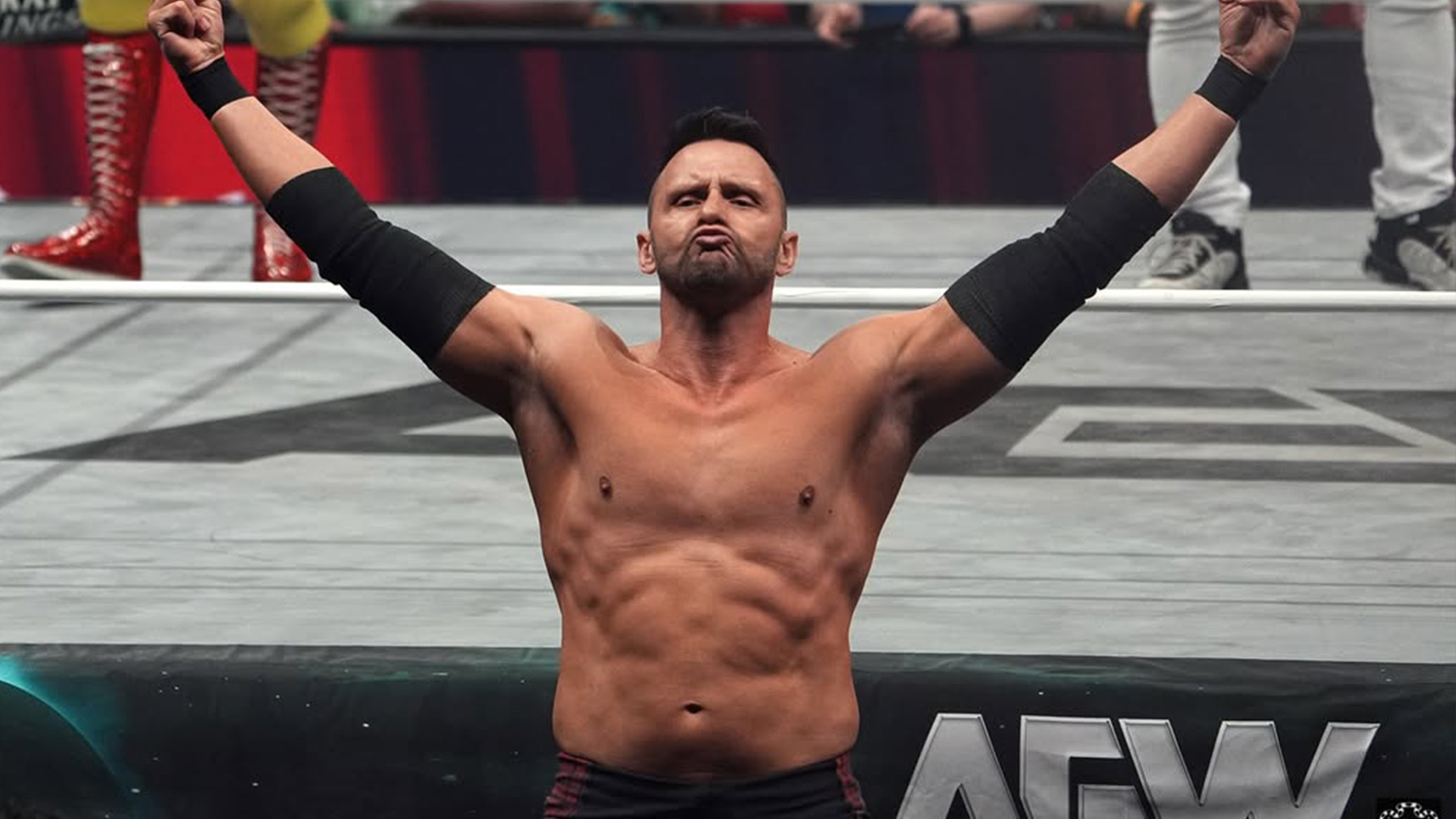 Nigel McGuinness throws four fingers in the air while outside the ring at AEW Double or Nothing 2025