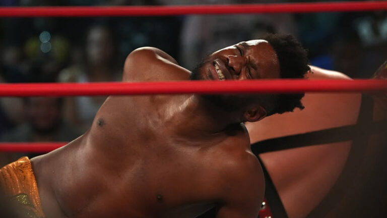 Michael Oku grabs his back in pain while wrestling Hechicero in ROH